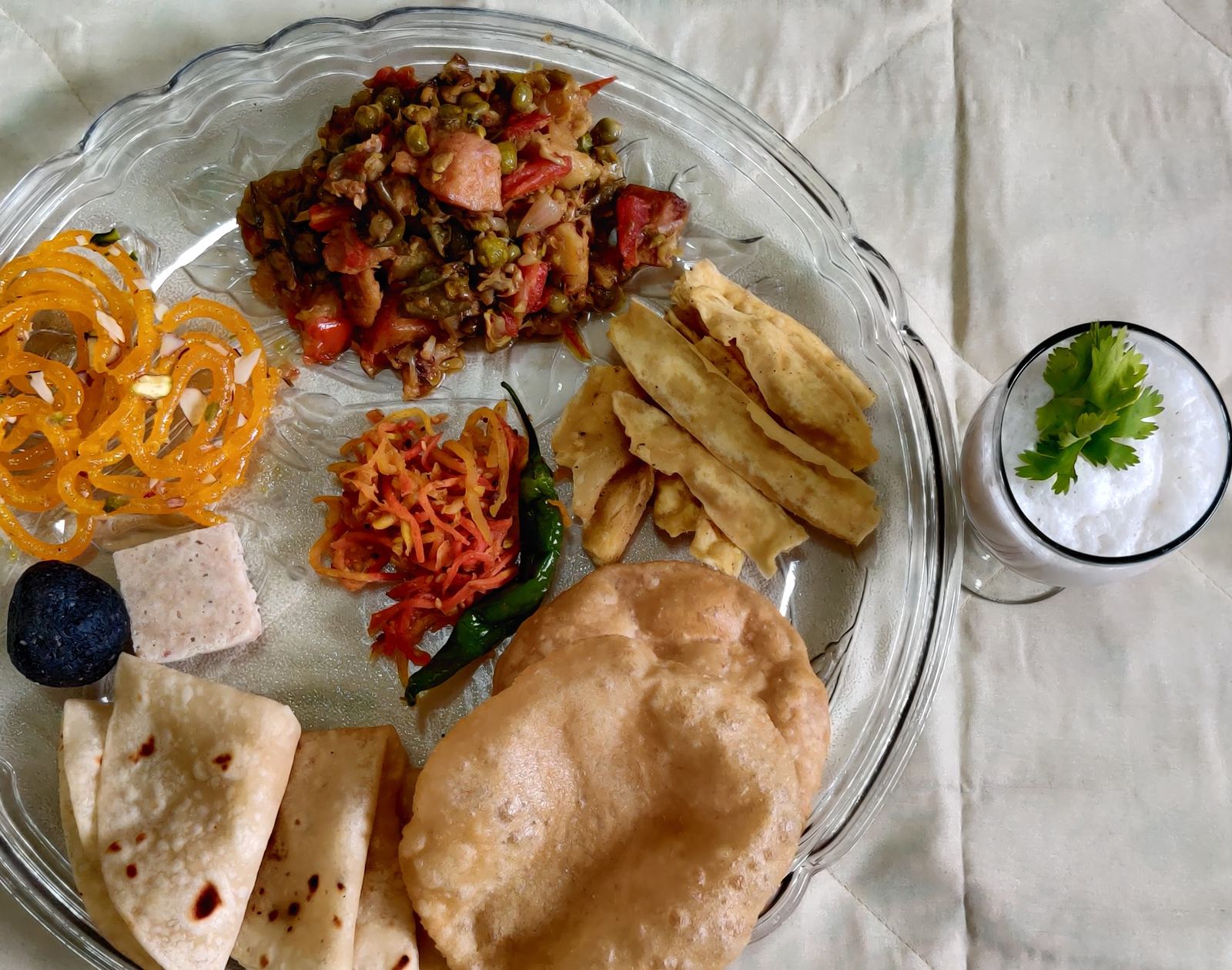 Festive Gujarati catering spread with Undhiyu, Puri, and Shrikhand laid out flat-lay style