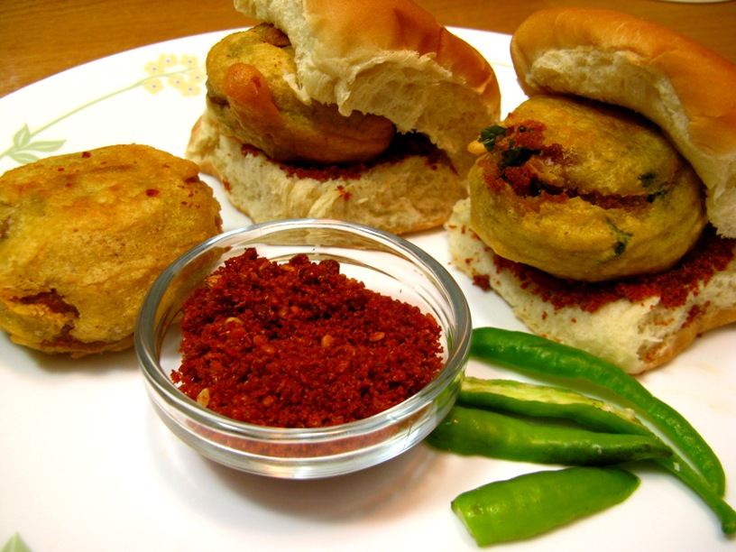 Vadapav with green chillies and chutney, flat-lay on a plate